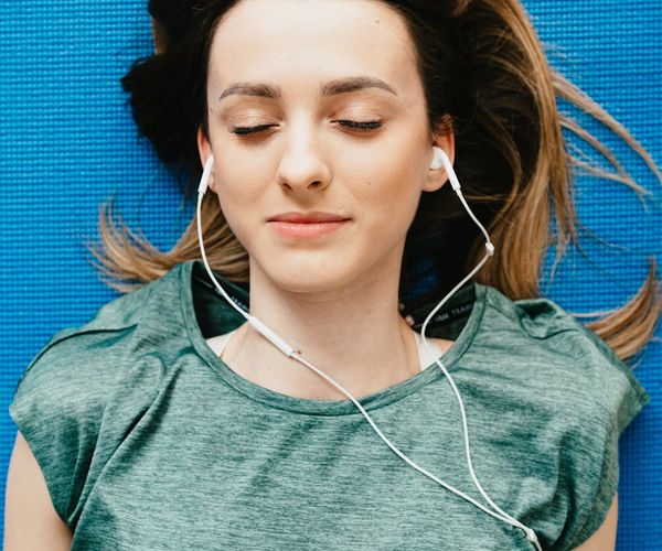 Young child lying on a yoga mat with eyes closed in a relaxation pose.